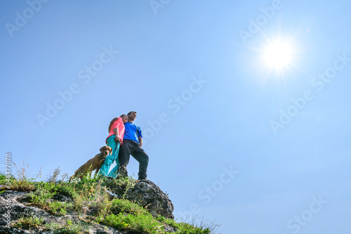 Junges Paar mit Hund genießt den herrlichen Ausblick beim Wandern