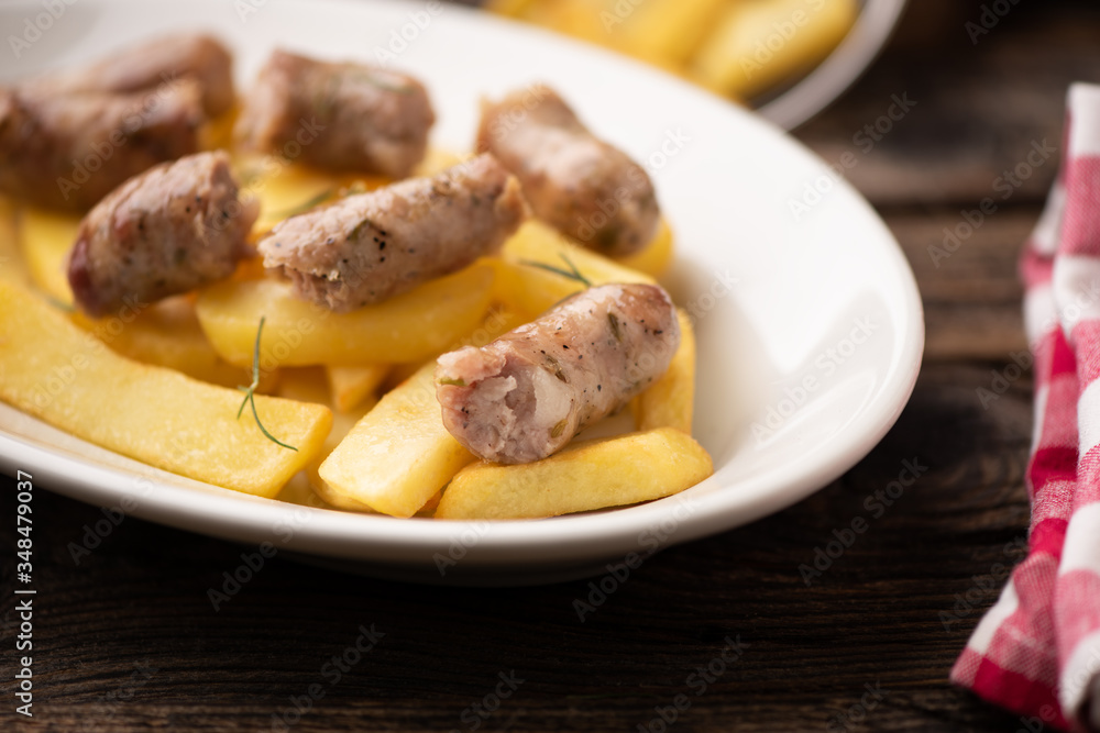 Fried potatoes with italian traditional salsiccia, selective focus