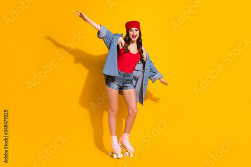 Full length photo positive youth street style girl hold hands imagine she fast speedy plane riding roller skates wear red headwear denim jeans singlet isolated bright color background