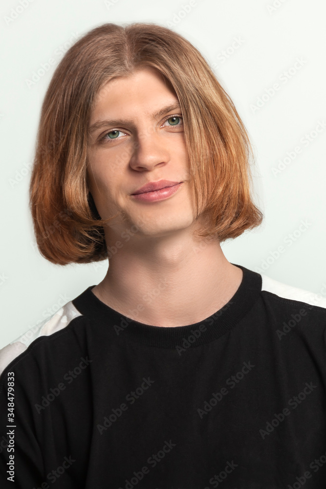 Close up portrait of young handsome guy with red ginger hear, slightly smiling, looking right to the camera. Wearing casual black shirt. Light gray background, studio, copy space. Close up portrait of young handsome guy with red ginger hear, slightly smiling, looking right to the camera. Wearing casual black shirt. Light gray background, studio, copy space.