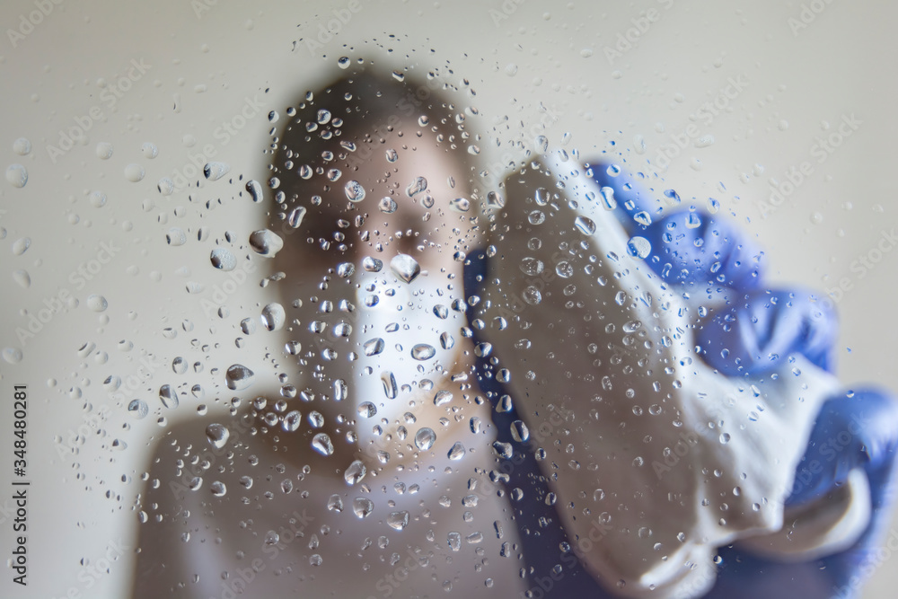 caucasian woman cleaning and disinfecting a glass with a cloth and spray in Spain