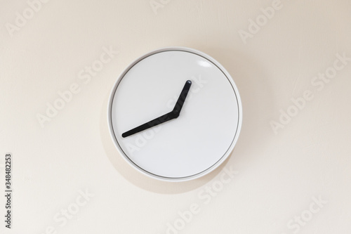 close up view of white minimalist clock without numbers hanging on the wall