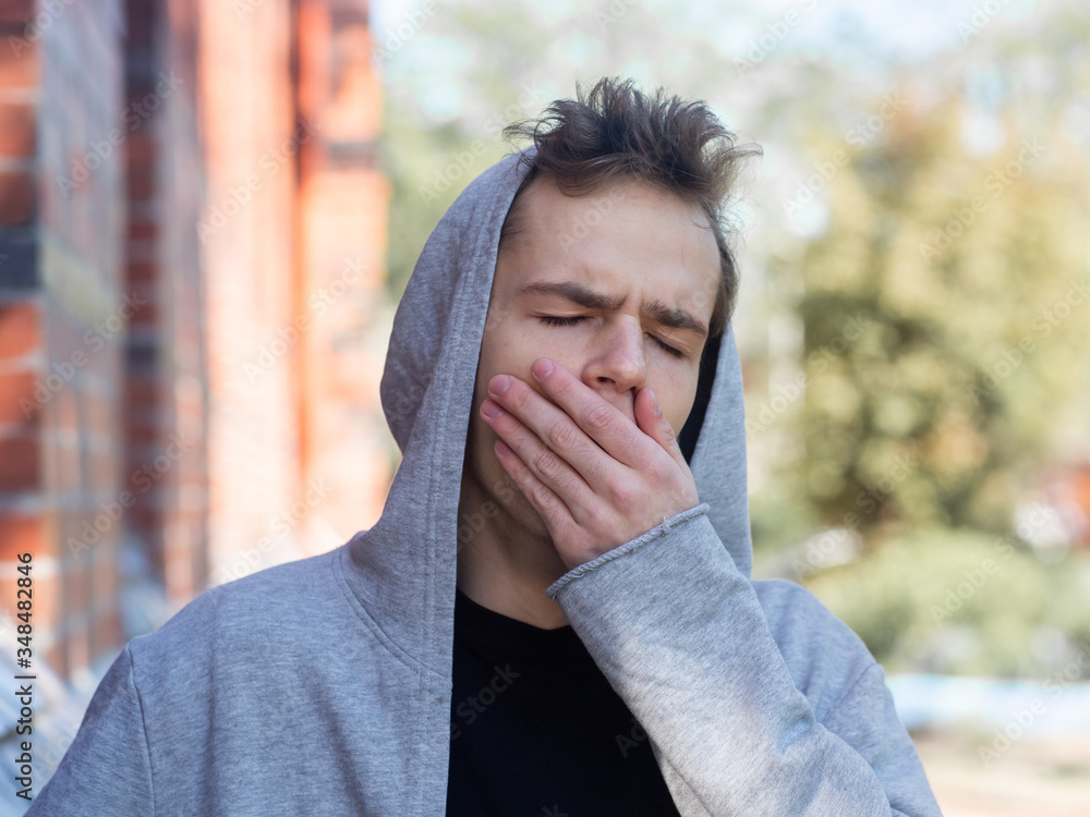 Φωτογραφία street portrait of yawning teenager
