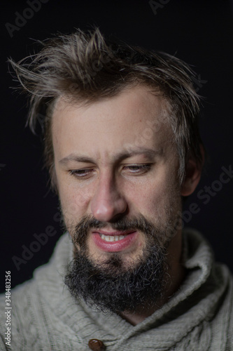 a young man with a beard rumpled appearance in a sweater. The fight against alcoholism © Kateryna
