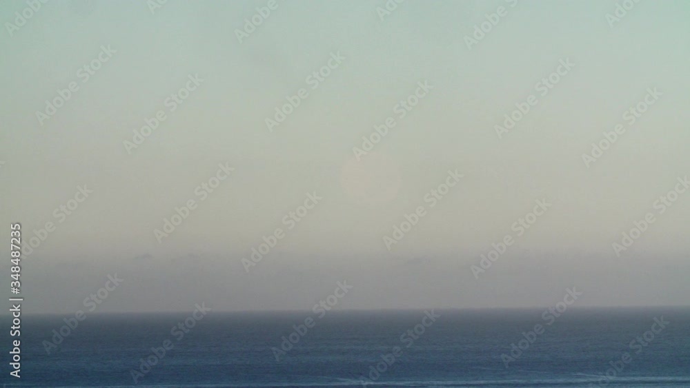 Time lapse of a full moon setting over the ocean at dawn Time lapse of a full moon setting over the ocean at dawn
