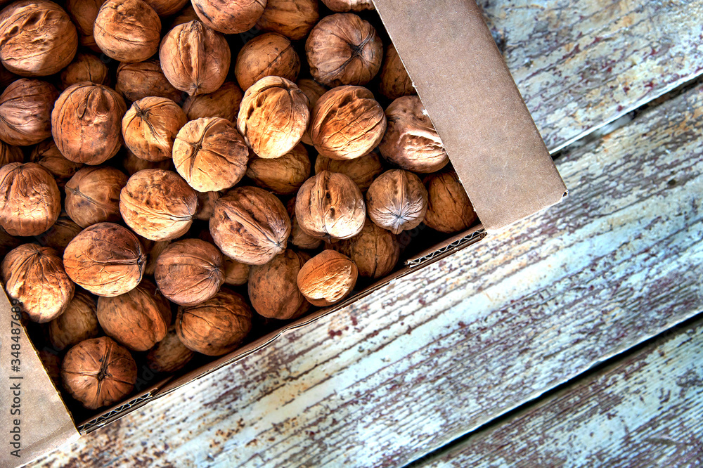 Top view walnuts in box on wooden background with copy space Top view walnuts in box on wooden background with copy space