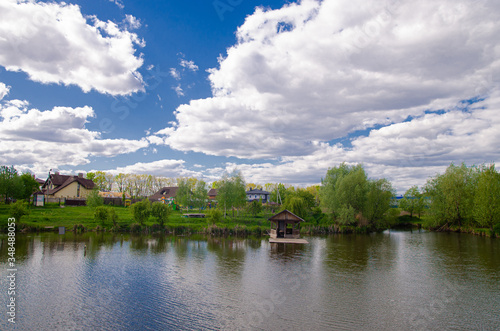 Beautiful quiet lake with a wooden gazebo in a rural cottage village. Country holiday.