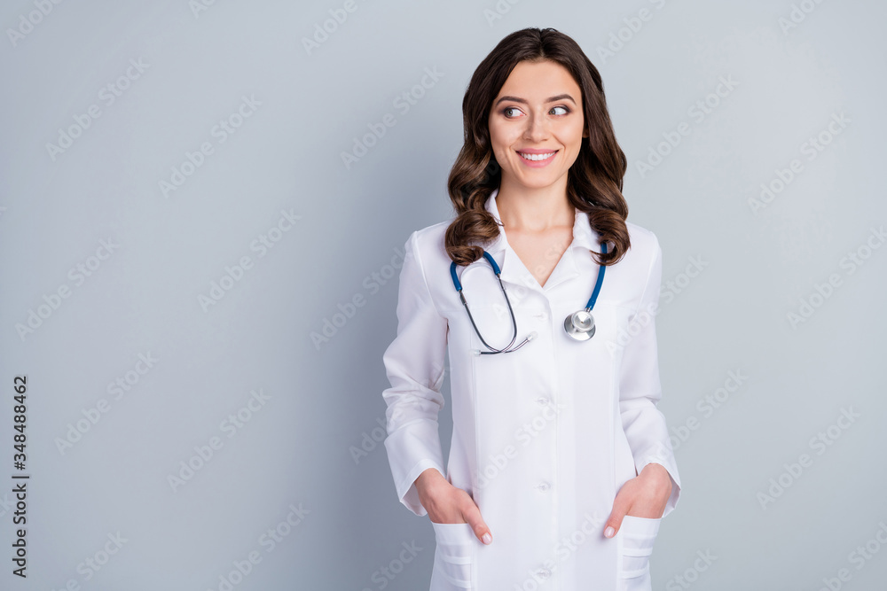 Photo of attractive family doc experienced lady consultant assistant virology clinic look side empty space beaming smile wear white lab coat stethoscope isolated grey color background Photo of attractive family doc experienced lady consultant assistant virology clinic look side empty space beaming smile wear white lab coat stethoscope isolated grey color background