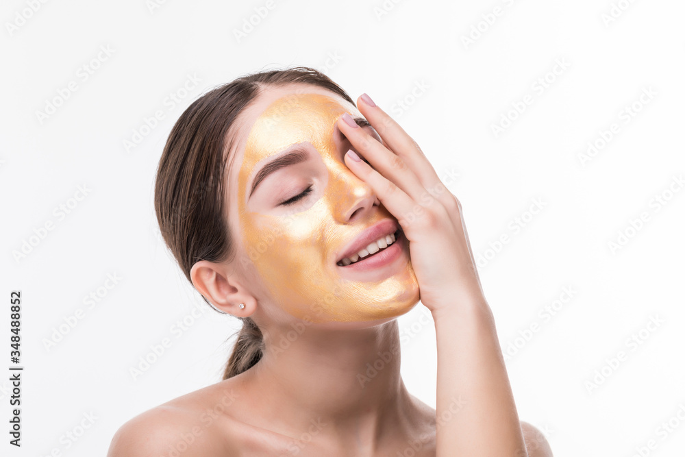 Young pretty woman make cosmetics gold mask for skincare isolated on white background Young pretty woman make cosmetics gold mask for skincare isolated on white background