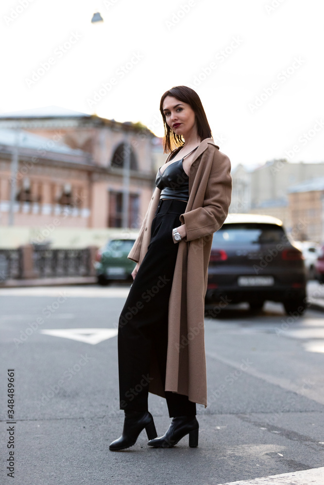 Fototapeta premium Woman in black pantsuit walks on promenade