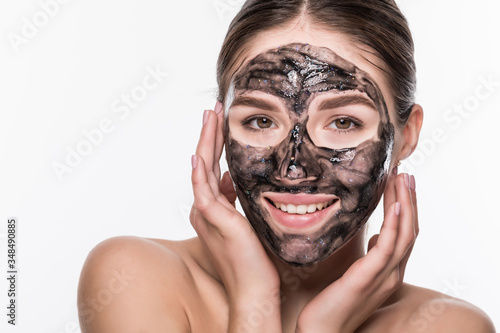 Young beautiful woman in a mask for the face of the therapeutic black mud. Spa treatment