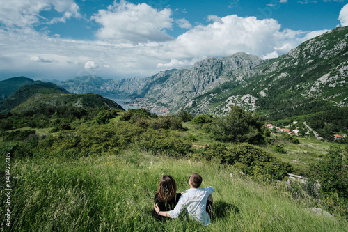 Back view of Romantic couple enjoy the view of the mountains on a sunny day in Montenegro photo