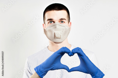 Optimistic doctor in protective mask making heart. Healthcare, medicine and treatment concept photo