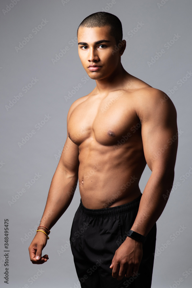Attraktiver muskulöser Mann posiert vor grauem Hintergrund