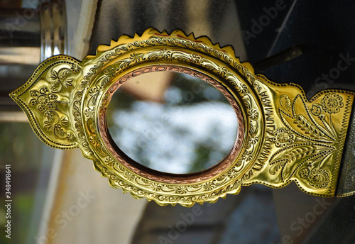 handmade metal alloy mirror called Aranmula mirror with golden frame in antique shop in kochi kerala  photo