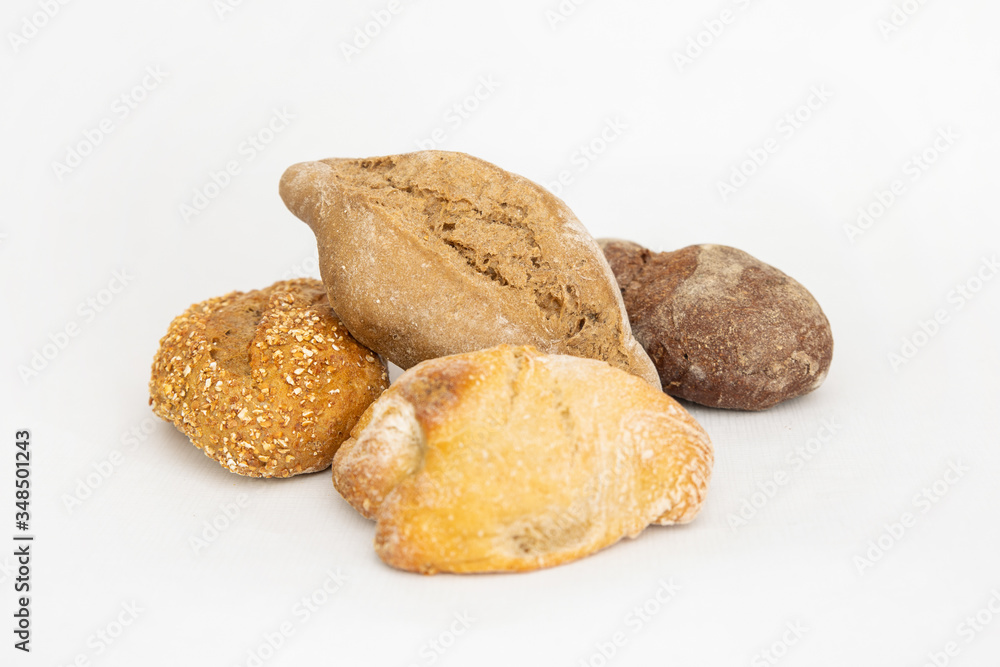 Batch of various baked breads. Fresh loafs made of wheat and rye flour isolated on white background. Studio shot. Side view. Homemade bakery and cooking at home concept Batch of various baked breads. Fresh loafs made of wheat and rye flour isolated on white background. Studio shot. Side view. Homemade bakery and cooking at home concept