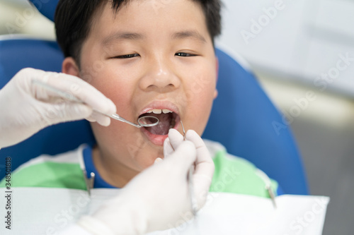 An Asian boy having teeth examined at dentists: Healthy lifestyle, healthcare, and medicine concept.