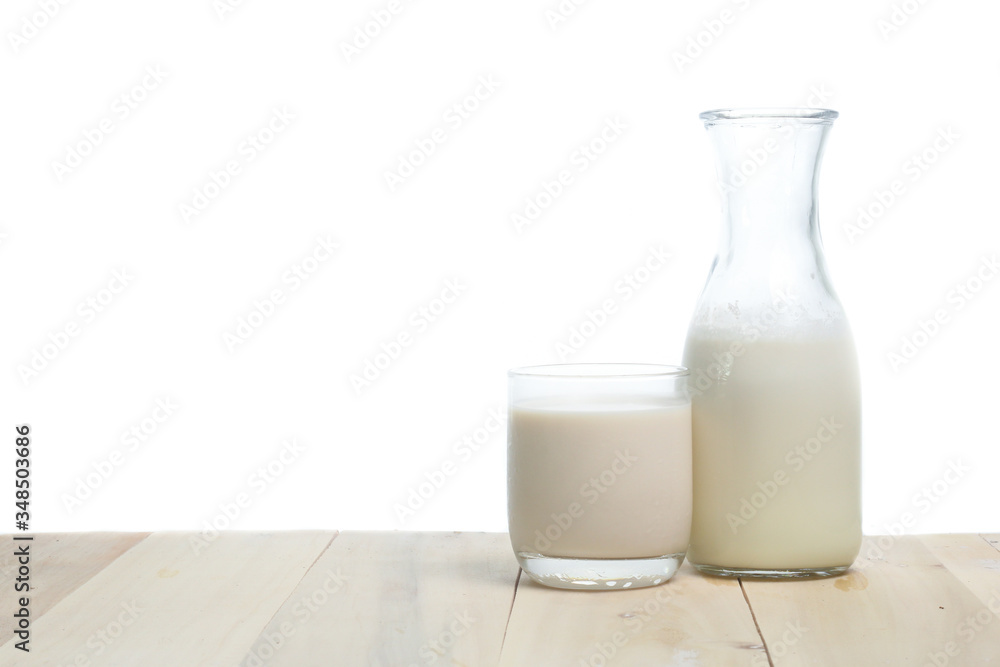 Milk in glass and in jar on table isolated on white background Milk in glass and in jar on table isolated on white background