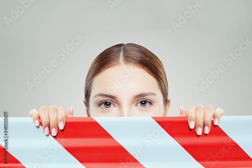 Canvas Print Cute woman looking out warning tape. Quarantine End