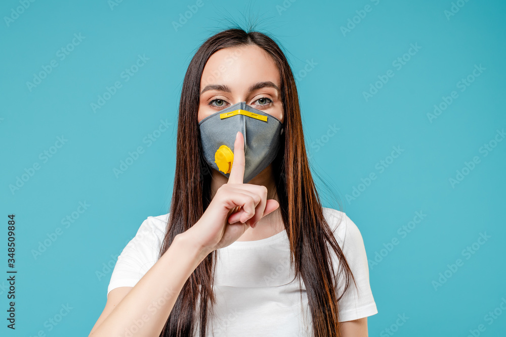 woman showing silence wearing respirator mask isolated on blue background woman showing silence wearing respirator mask isolated on blue background
