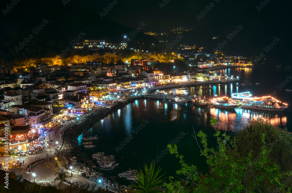 Fototapeta premium the city of Parga, by the mediterranean sea, with it's houses and boats in the pier, at night