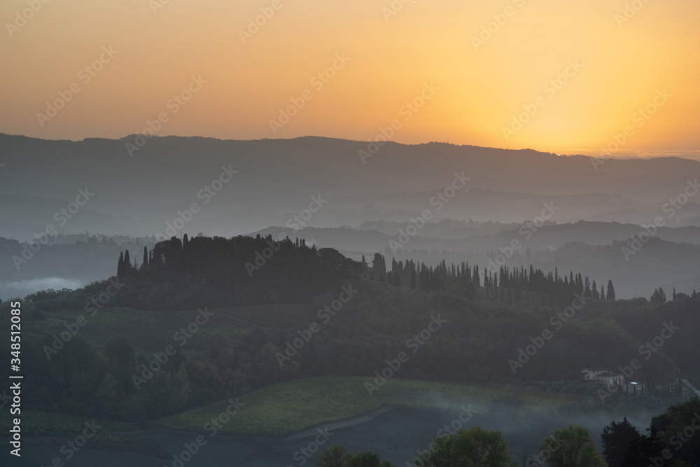 Tuscany landscape at sunrise. Typical for the region tuscan farm house, hills, vineyard. Italy