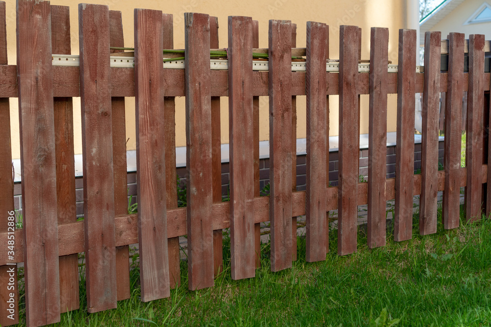 Wooden fence on a background of green grass. No people Wooden fence on a background of green grass. No people