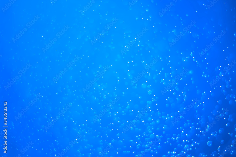 Blue glitter vintage lights background. Blue bokeh on black background.