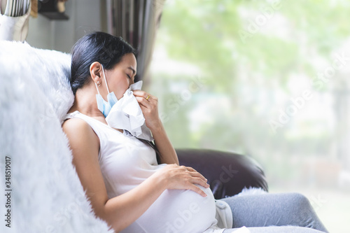 Obraz na płótnie Asian pregnant woman unwell with the symptom of fever, runny nose and sneezing of viral infection and allergy, concept of sickness and healthcare in pregnancy in the situation of covid 19 outbreak