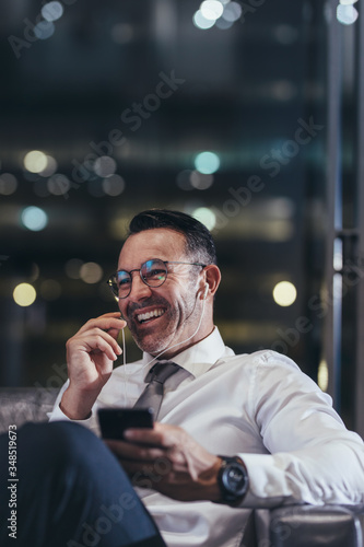 Businessman talking on phone at airport lounge