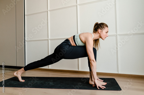 young woman doing sport on yoga mat at home