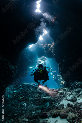 Fototapeta Naklejka Na Ścianę i Meble -  typical underwater cave in a red sea reef with an underwater photographer diver