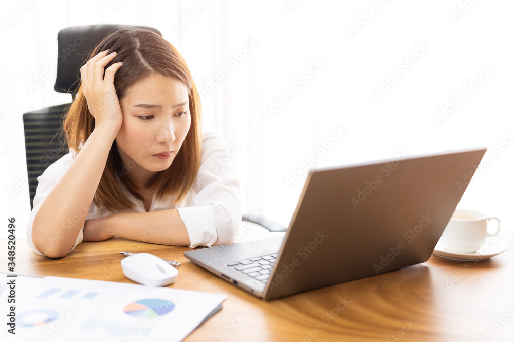 Stressed young Asian woman using laptop working at home Stressed young Asian woman using laptop working at home