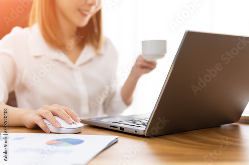Young woman sale person analzing sale report on desk working at home