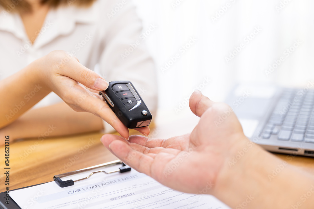 Car loan, contract agreement,buying and rent car concept, Saleperson holding car key on hand Car loan, contract agreement,buying and rent car concept, Saleperson holding car key on hand