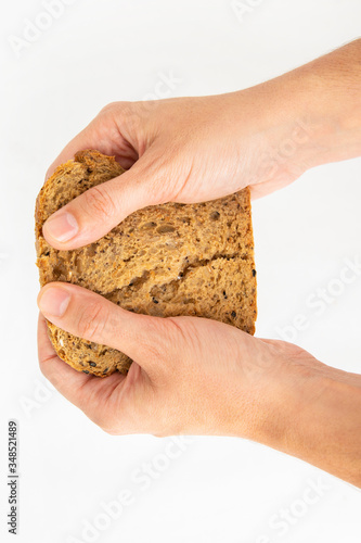 Female hands holding slice of cereal bread. Homemade rye loaf and pastry for sandwich isolated on white background. Studio shot. Top view. Cooking and baking at home concept