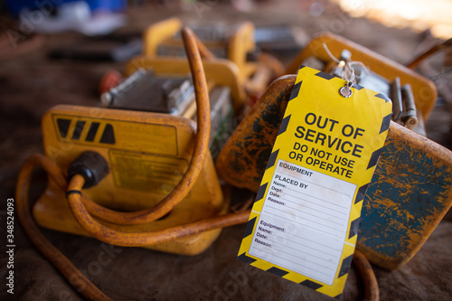 Safe workplace yellow out of service tag placing on RCD residual current devices as faulty damage equipment dangerous to used remove from services  
