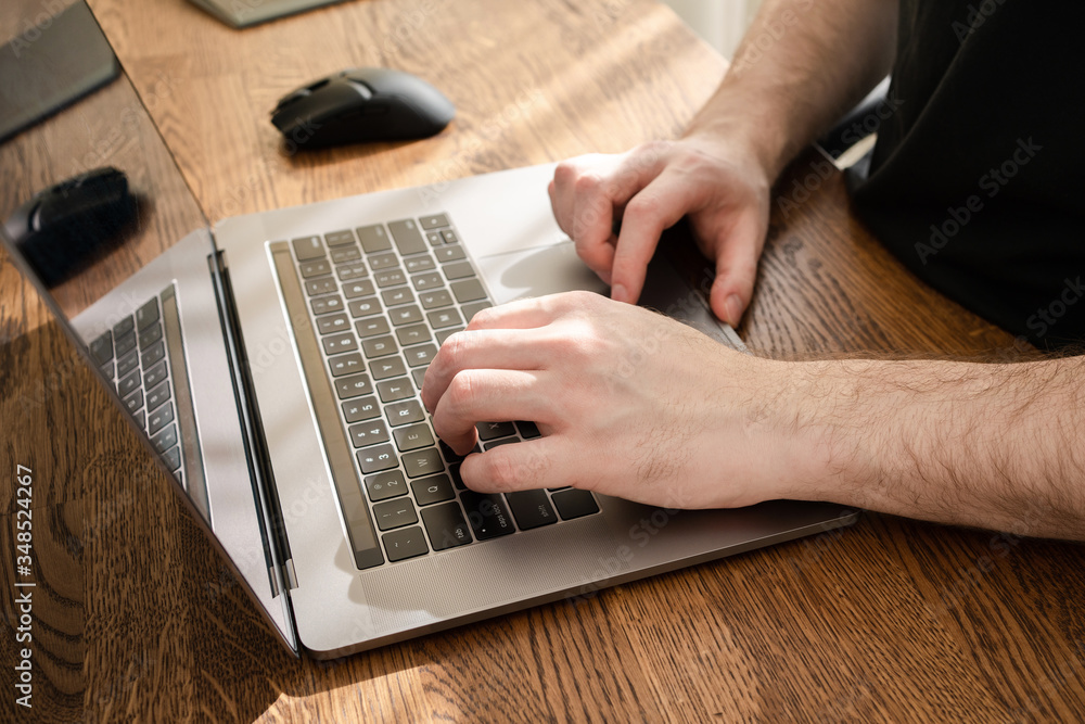 Fototapeta premium Man typing on laptop keyboard. Working from home.