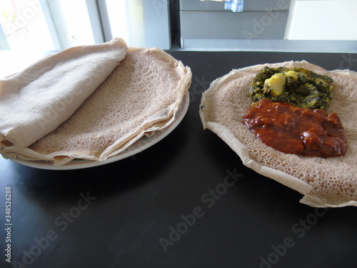 Asmara, Eritrea - 08/05/2020: Ethiopian and Eritrean food, assortment of main dishes. Injera is a sourdough flatbread made from teff flour. It is the national dish of Ethiopia, Eritrea. photo