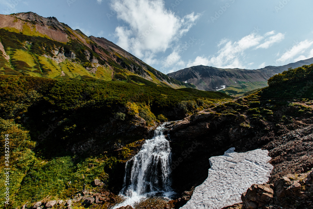 Waterfall in the mountain range. Kamchatka