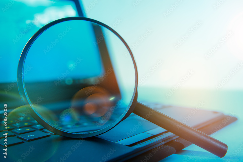 Laptop computer with magnifying glass, concept of search - obrazy, fototapety, plakaty 