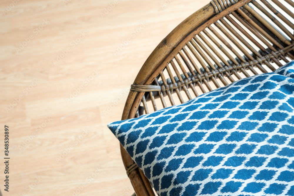 Obraz premium Natural rattan dining armchair on a wooden floor, rustic accent at the modern living room, close up shot