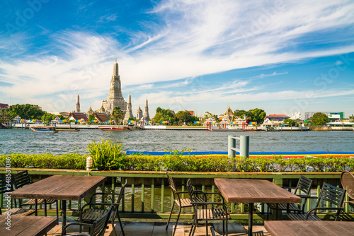 Obraz na plátně Emplty wooden table chair of riverside bar with buddhist temple view temple of d