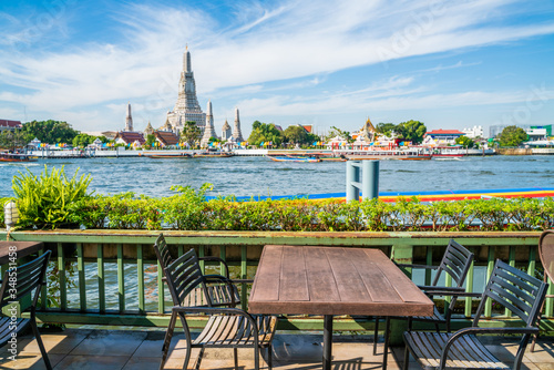 Photography Emplty wooden table chair of riverside bar with buddhist temple view temple of d