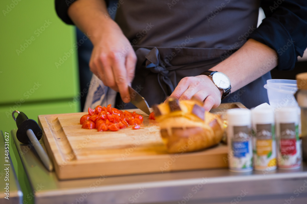 Man Cutting Cherry Tomatoes and Preparing a Meal on Wooden Chopping Board Man Cutting Cherry Tomatoes and Preparing a Meal on Wooden Chopping Board