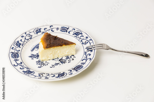 Basque Burnt Cheesecake with fork isolated in white background. photo