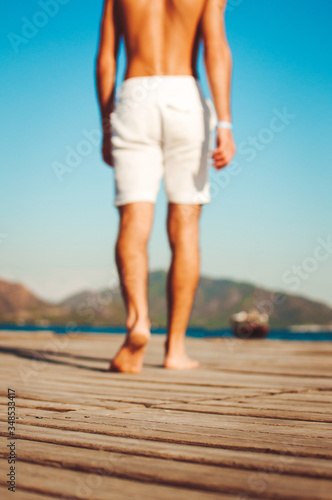 Unknown barefoot bronzed man in goes into the distance.