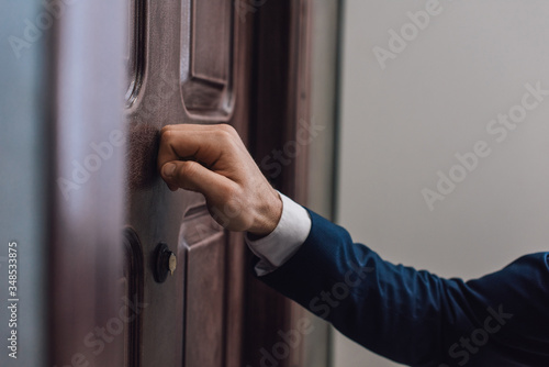 Cropped view of collector knocking on door with hand Fototapete