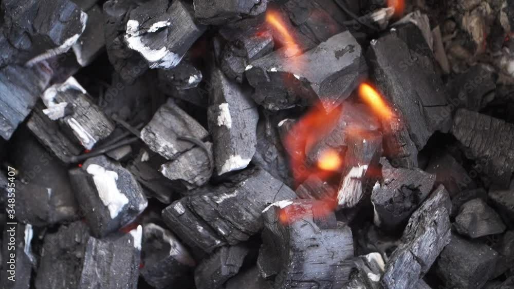 Close-up of burning coals in the barbecue grill. Coal is starting to burn. Cooking bonfire food. Top view. Slow motion
