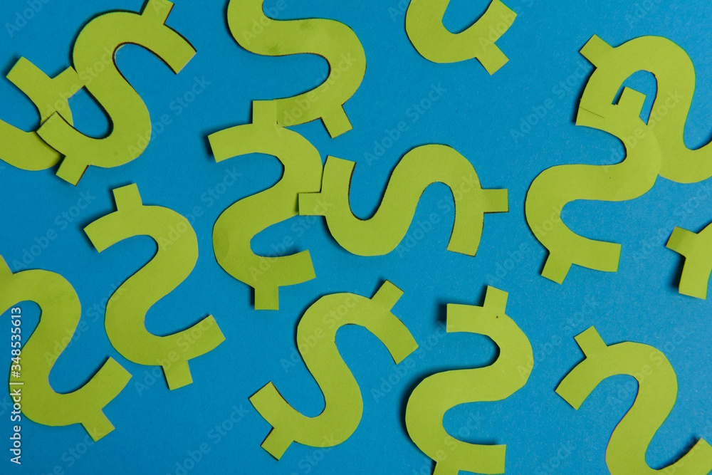 Paper yellow symbols of US dollar currency on blue background. View from above with copy space. Paper yellow symbols of US dollar currency on blue background. View from above with copy space.